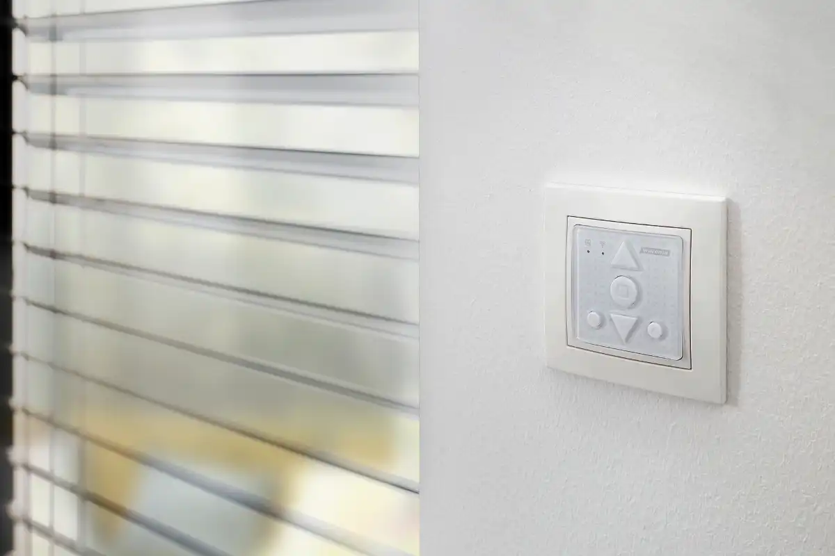 Elektrischer Rollladenschalter für Jalousien Elektrischer Rollladenschalter an der Wand neben geschlossenen Jalousien